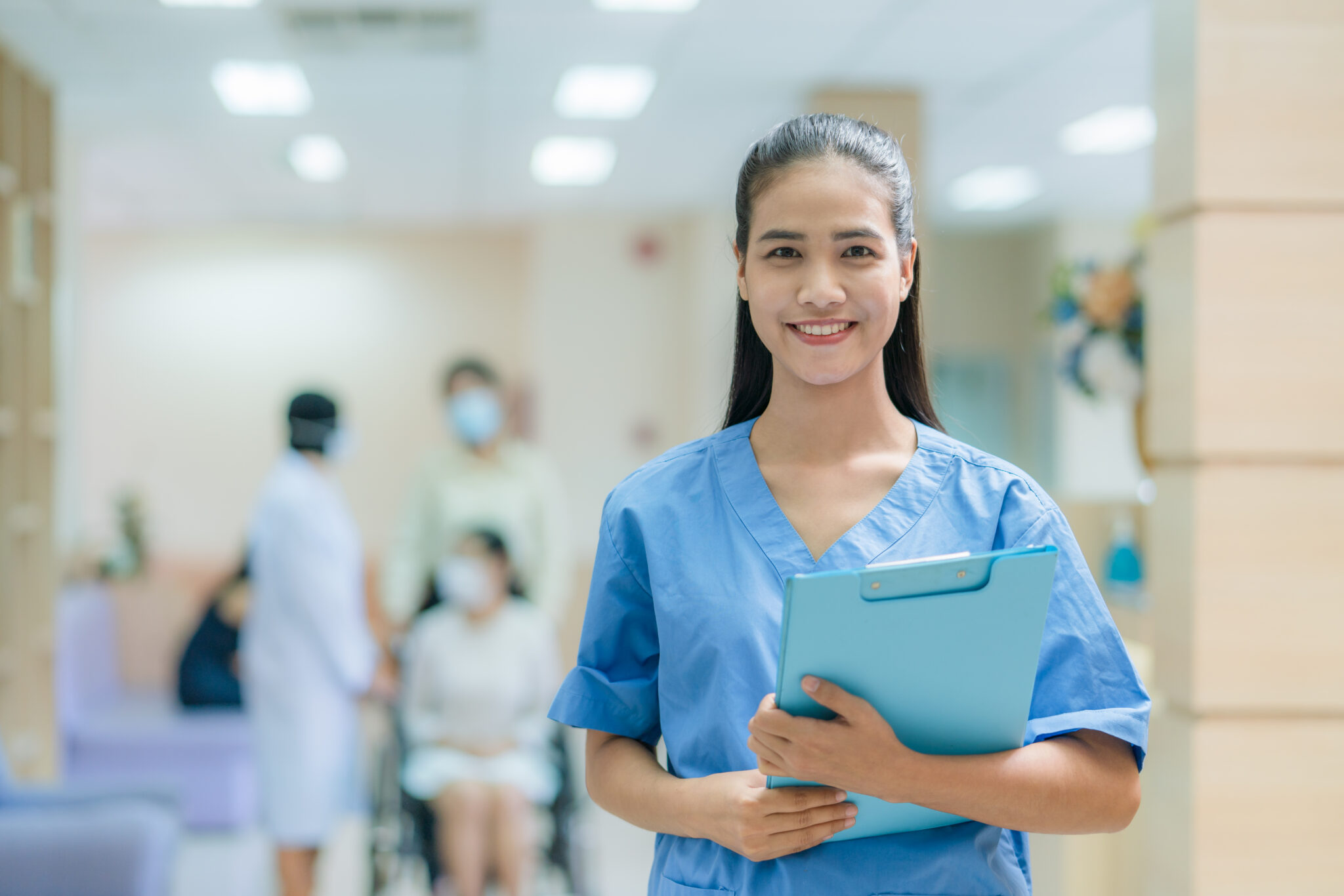 Portrait of Asian female nurse wearing uniform working in hospital with doctor and patient sitting on wheelchair background